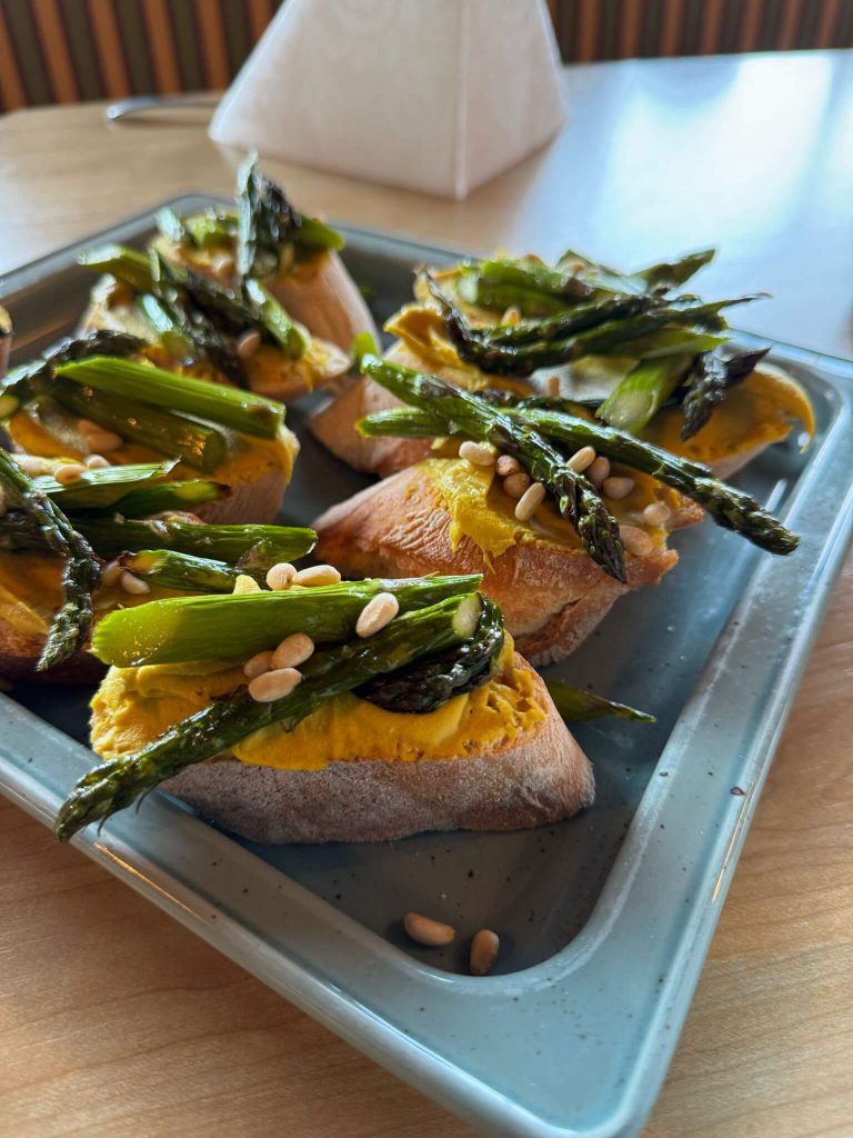 Geröstetes Brot mit Kürbiscreme, grünem Spargel und Pinienkernen als regionale Spezialität Piesendorf
